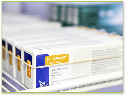 yellow and blue boxes of Norditropin 5mg rubber banded together